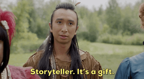 A person dressed in Native American-inspired clothing stands outdoors, saying, Storyteller. It's a gift and a powerful storytelling tool, in yellow text, with trees and greenery in the background.
