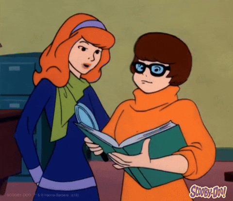 Animated image of two characters from Scooby-Doo, using intelligent strategies as they discuss an open book—proving teamwork and smart thinking are keys to marketing success.