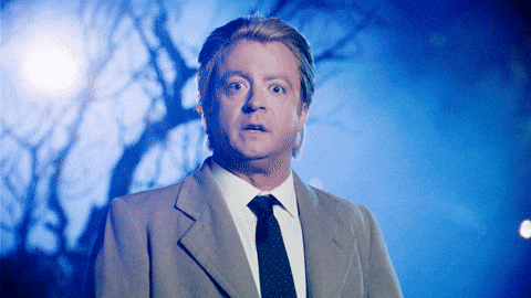 A man in a suit and tie stands outside at night with a shocked expression, his eyes widening dramatically. Blue light and eerie trees set the scene, as if he’s just uncovered powerful headline writing tips in a suspenseful atmosphere.