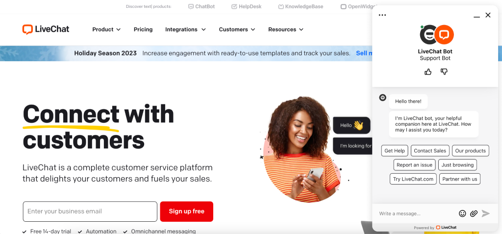 Screenshot of the LiveChat brand website design homepage featuring a smiling woman with curly hair holding a mobile. On the right, a LiveChat Bot window, crafted with the ideal customer in mind, offers help options like “Contact Sales.”.